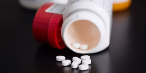 Prescription bottle and pills on a table.